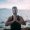 Young man doing yoga by the sea. A handsome guy is sitting on the ocean at sunset.